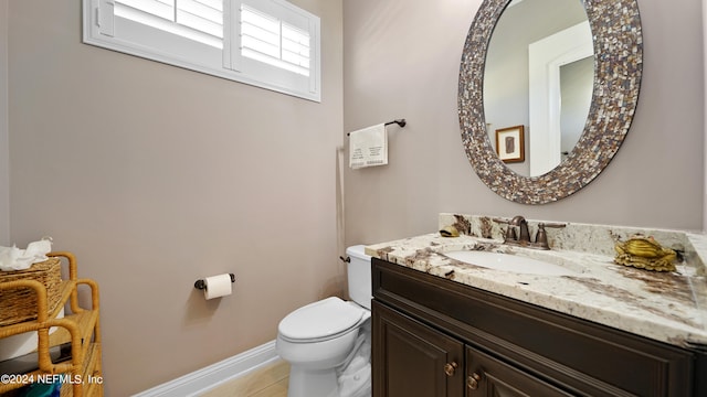 bathroom with vanity with extensive cabinet space, toilet, and tile floors