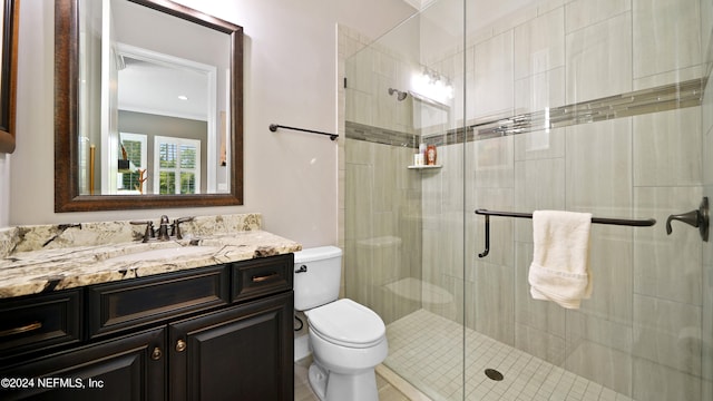 bathroom featuring a shower with door, toilet, and large vanity