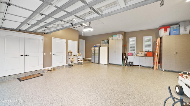 garage with refrigerator, stainless steel fridge, and a garage door opener