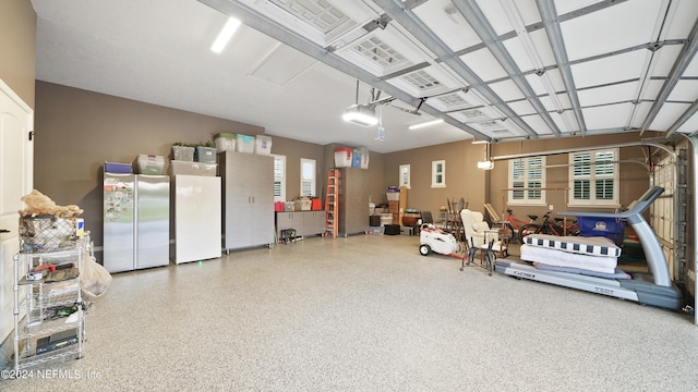 garage with refrigerator, stainless steel fridge, and a garage door opener