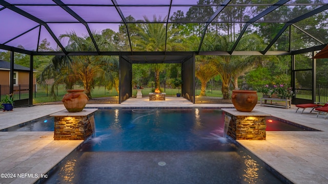 pool at dusk featuring a patio area, pool water feature, and glass enclosure