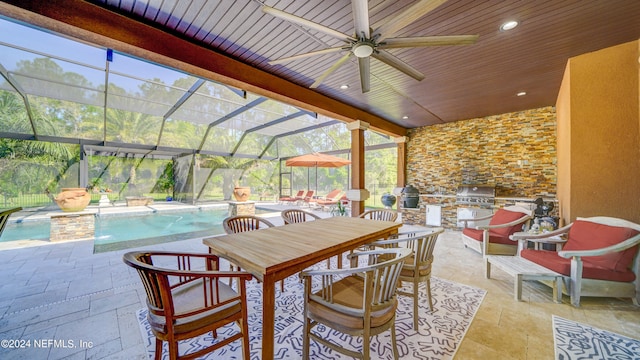 exterior space with ceiling fan, grilling area, and glass enclosure