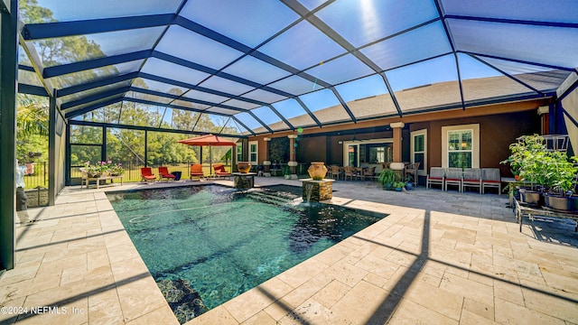 view of pool with a patio, ceiling fan, a lanai, and pool water feature