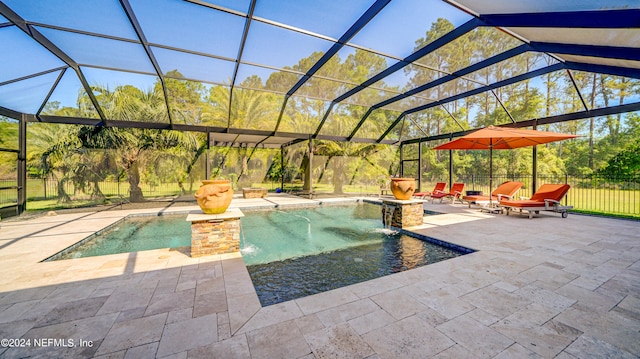 view of pool with a patio, glass enclosure, and pool water feature