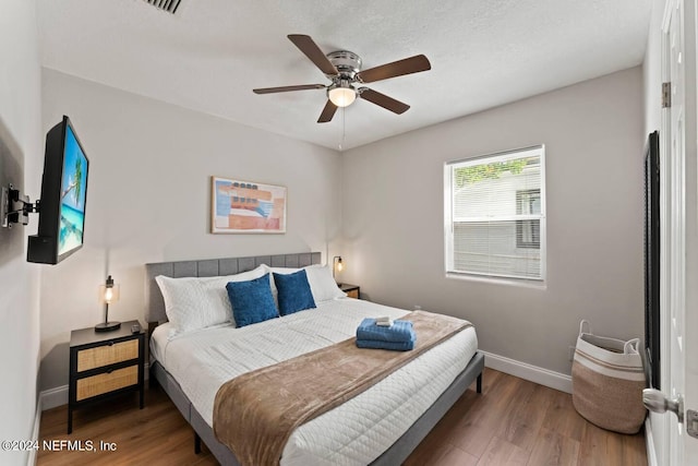 bedroom with dark hardwood / wood-style flooring and ceiling fan