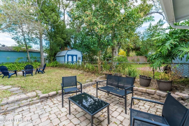 view of patio featuring a fire pit and a storage unit