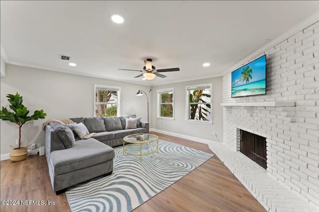 living room with light hardwood / wood-style flooring, crown molding, and a fireplace