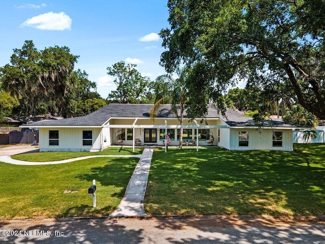 ranch-style home featuring a front yard and fence