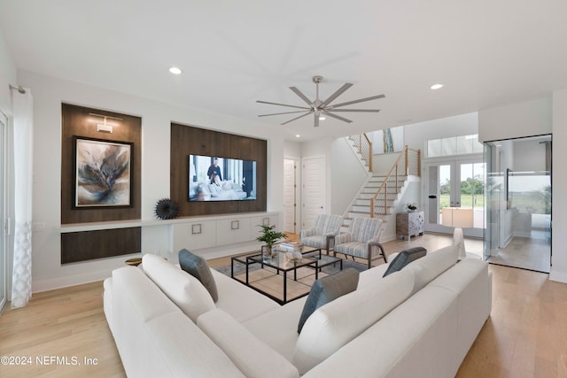 living room with light hardwood / wood-style flooring and ceiling fan