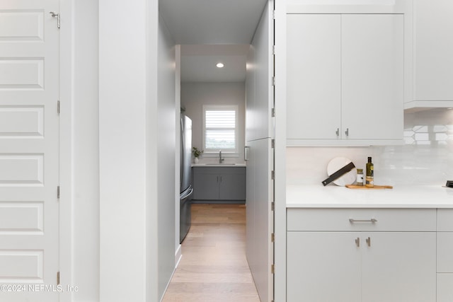 corridor featuring sink and light hardwood / wood-style flooring