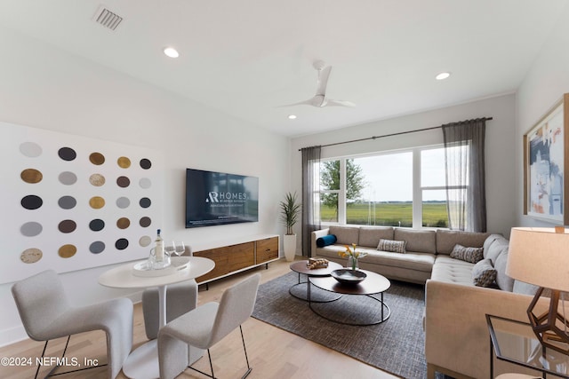 living room featuring light hardwood / wood-style floors and ceiling fan