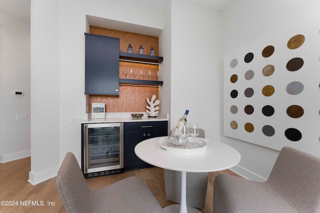 interior space with light hardwood / wood-style flooring, tasteful backsplash, and wine cooler