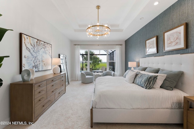 carpeted bedroom with a chandelier and a tray ceiling