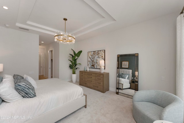 bedroom with a notable chandelier, a tray ceiling, and light carpet