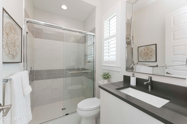 bathroom with tile floors, a healthy amount of sunlight, toilet, and a shower with shower door