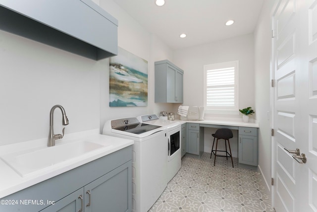 clothes washing area featuring washer and dryer, cabinets, sink, and light tile flooring