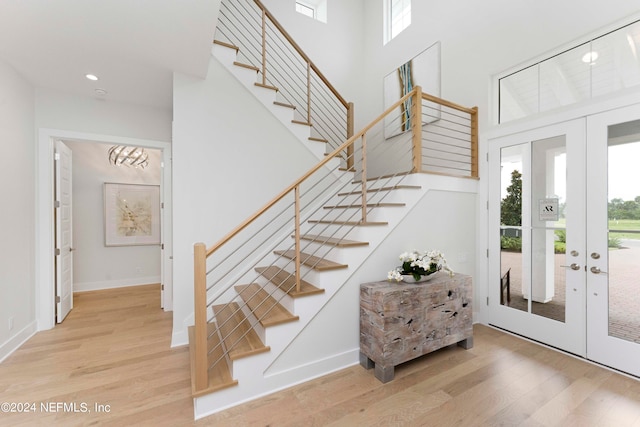 staircase with french doors and light wood-type flooring