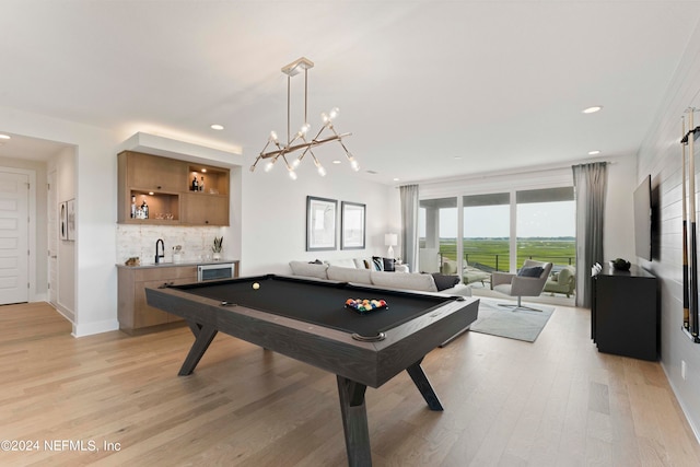 recreation room with an inviting chandelier, light hardwood / wood-style floors, pool table, and sink