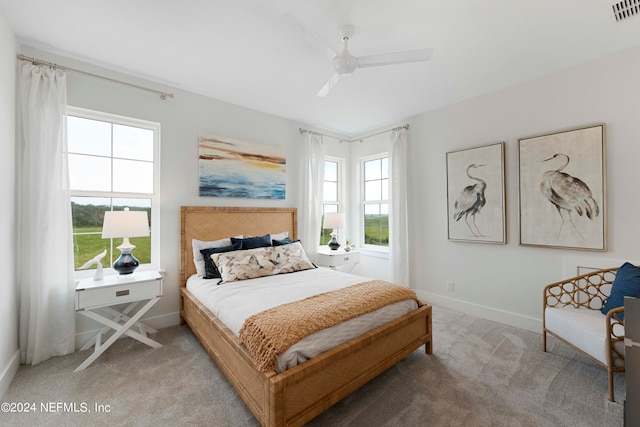 carpeted bedroom with multiple windows and ceiling fan