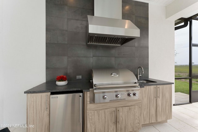 kitchen featuring tile walls, refrigerator, wall chimney exhaust hood, sink, and light tile floors