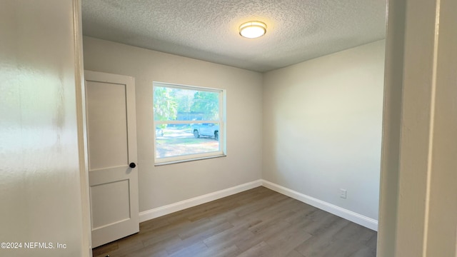 spare room with light hardwood / wood-style flooring and a textured ceiling