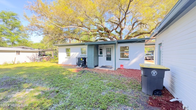 back of house with a yard and central AC unit