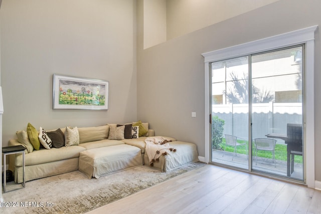 living room with a high ceiling and light wood-type flooring