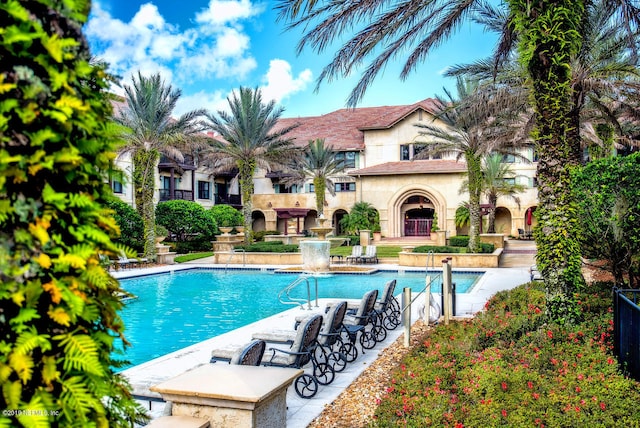 view of pool featuring pool water feature and a patio