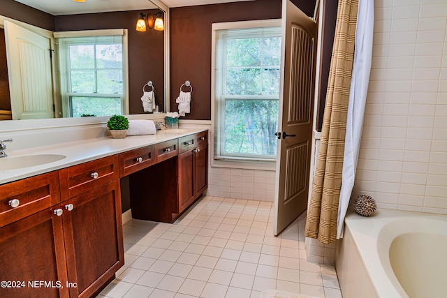 bathroom featuring plenty of natural light, vanity, and a relaxing tiled tub