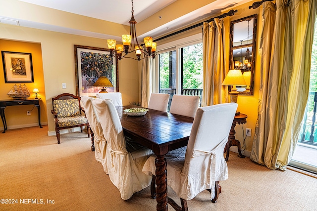 carpeted dining area with an inviting chandelier