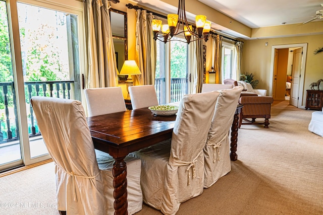 carpeted dining space featuring a chandelier