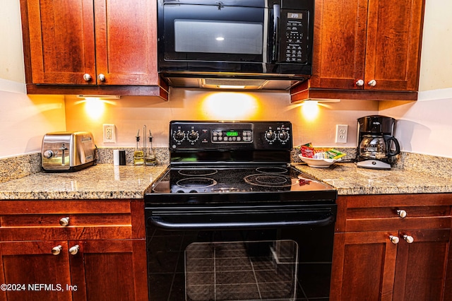 kitchen with black appliances and light stone countertops