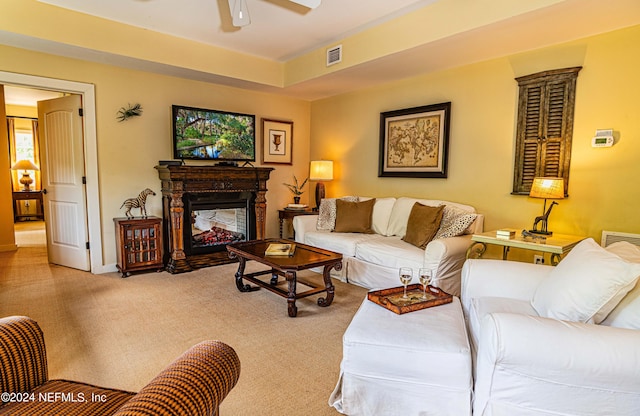 carpeted living room featuring a multi sided fireplace and ceiling fan