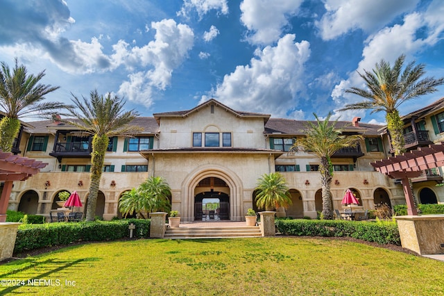 exterior space featuring a balcony and a front lawn