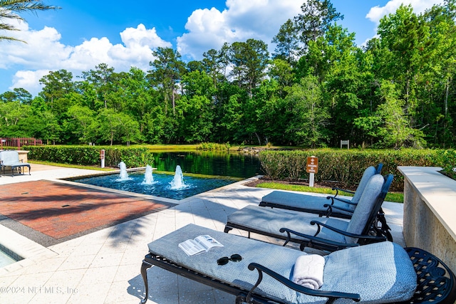 view of pool featuring a water view and a patio area