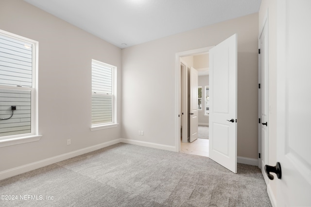 unfurnished bedroom featuring light carpet