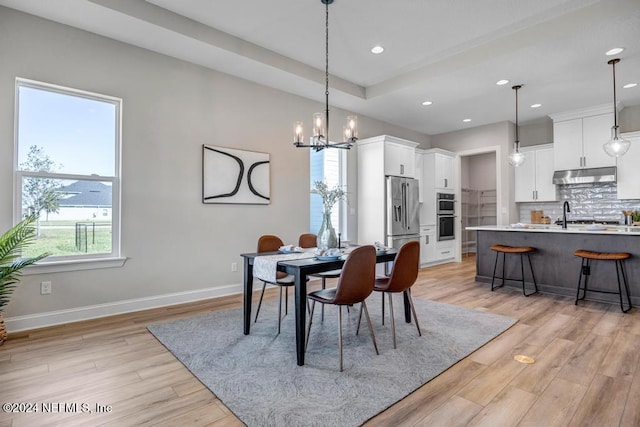 dining area featuring a chandelier, light wood-type flooring, and a healthy amount of sunlight