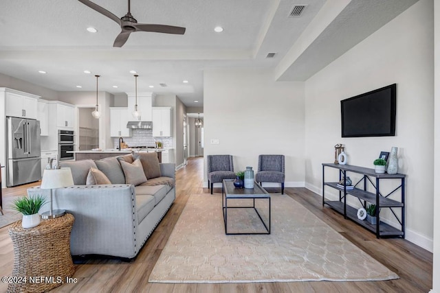 living room with ceiling fan and light hardwood / wood-style floors