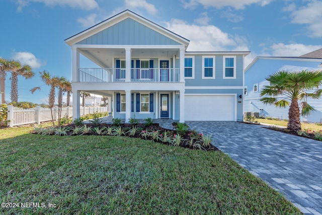 view of front of house featuring a balcony, a front lawn, and a garage