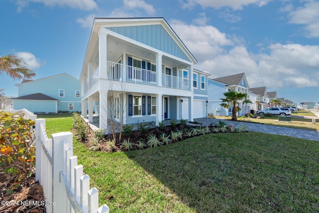 view of front of home featuring a balcony, a garage, and a front lawn