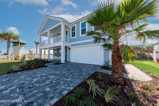 view of front of property with a balcony, a garage, and a front lawn