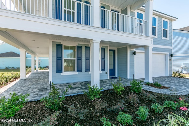 entrance to property with a garage and a balcony