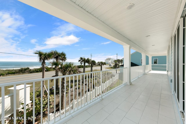 balcony featuring a water view and a view of the beach