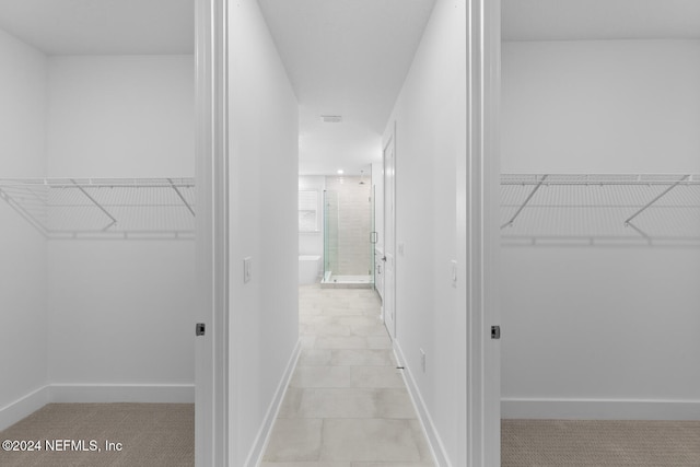 walk in closet with light tile patterned flooring