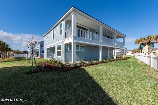 rear view of property with a balcony and a yard