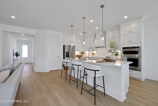 25 Seaside Vista Ct, Saint Augustine, FL 32084 - kitchen featuring stainless steel appliances, a breakfast bar, light wood-type flooring, white cabinetry, and recessed lighting