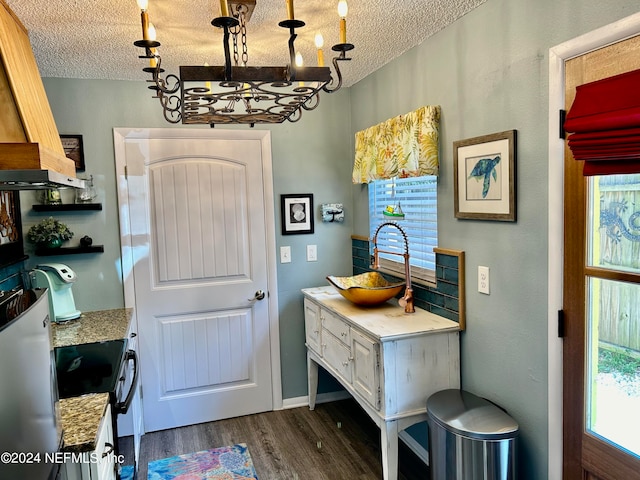 doorway to outside with dark hardwood / wood-style flooring, a notable chandelier, and a textured ceiling