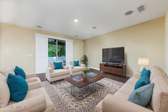 living room with wood-type flooring and a textured ceiling