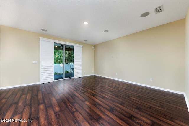 unfurnished room featuring dark hardwood / wood-style floors and a textured ceiling