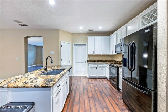 kitchen with black appliances, sink, stone countertops, white cabinetry, and dark wood-type flooring